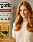 Woman with reddish blonde hair next to a packet of Colour Me Organic hair color on a wooden table.