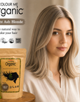 Woman with light ash blonde hair next to 'Colour Me Organic' hair color packaging.