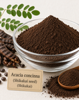 A clear glass bowl filled with dark brown Acacia concinna powder, shown with whole seed pods, loose seeds, a wooden spoon, and a small label reading 'Acacia concinna (Shikakai seed) (Shikakai)'.