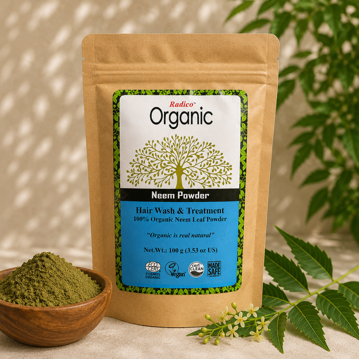 A stand-up pouch of Radico Organic Neem Powder hair wash and treatment, shown with a small wooden bowl of green powder and neem leaves on a beige surface.