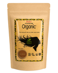 A stand-up kraft paper pouch of Radico Colour Me Organic hair color powder, shown against a plain white background. The packaging features a central label with a black silhouette of hair, a green leaf, and a brown powder swatch labeled 'Sun Blonde'.
